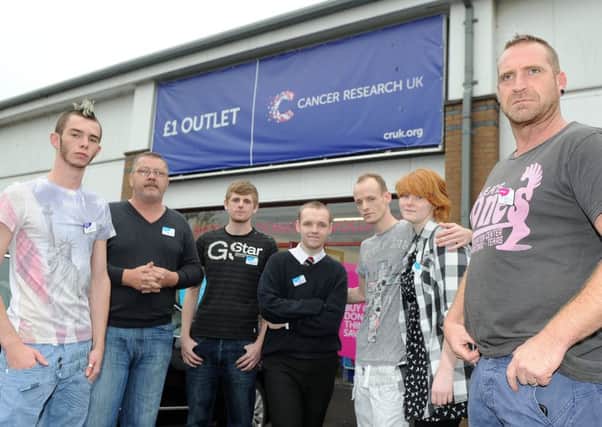 The manager of the cancer research shop, Joe Orrock, right, and staff outside the Corstorphine shop. Picture: Neil Hanna