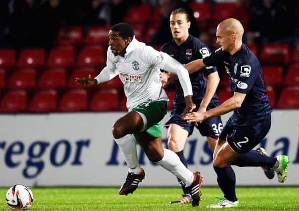 Hibernian's Dominique Malonga (left) is challenged by Tim Dreesen of Ross County in the League Cup third round tie.