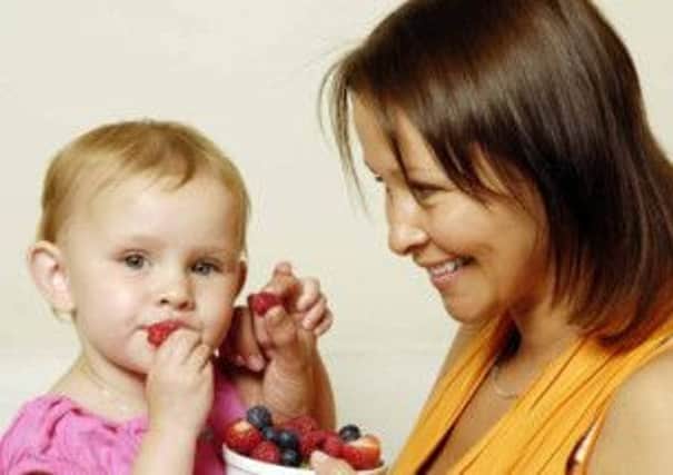 Julie Shaw-Binns feeds daughter Loisa a tasty treat of berries. Picture: contributed