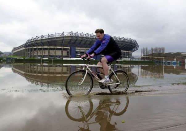A cyclist braves the floodwater at Roseburn Park back in April 2000. Picture: Sandy Young