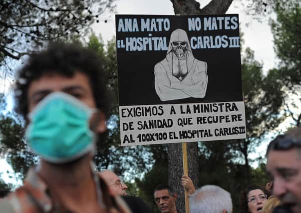 A health worker protests outside the hospital in Madrid where a nurse is being treated for the virus. Picture: Getty