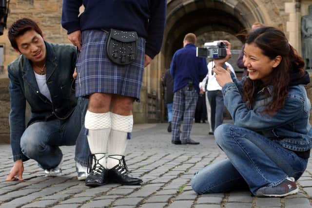 Tourists Shimy Fangfang and John Zuoming admire a Castle guards kilt. Picture: Toby Williams