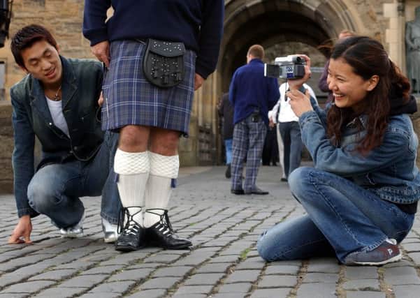 Tourists Shimy Fangfang and John Zuoming admire a Castle guards kilt. Picture: Toby Williams