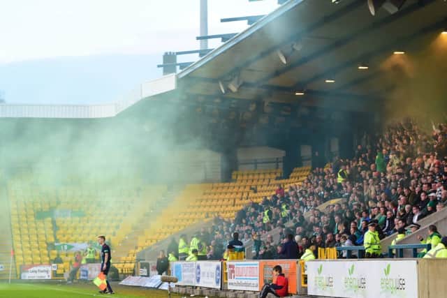 Smoke drifts towards the pitch after Hibs fans set off smoke bombs at their game versus Livingston. Picture: SNS