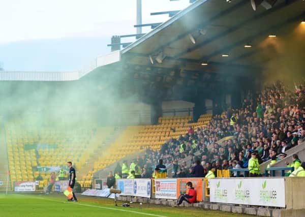 Smoke drifts towards the pitch after Hibs fans set off smoke bombs at their game versus Livingston. Picture: SNS