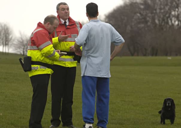 Environmental wardens speak to a dog walker in Holyrood Park. Picture: Toby Williams