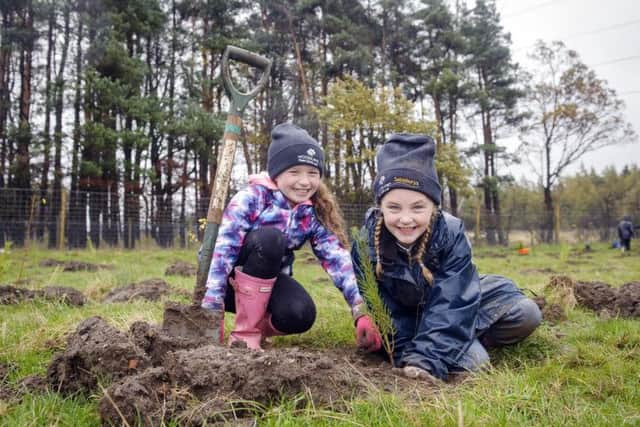 Currie Primary pupils Rosie and Karis help with the planting. Picture: Helen Pugh