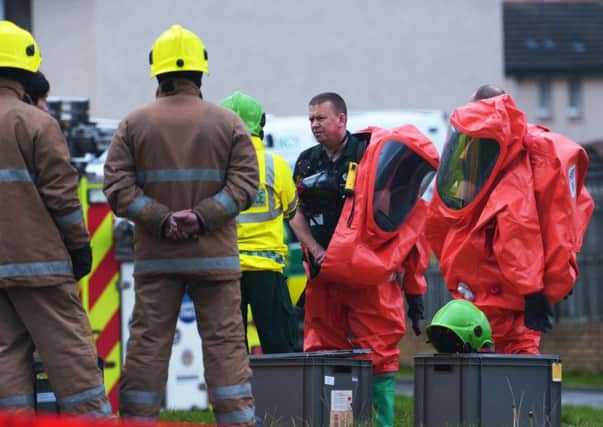 Police and fire crews in protective chemical clothing at the incident in Clovenstone Park. Pic: Phil Wilkinson