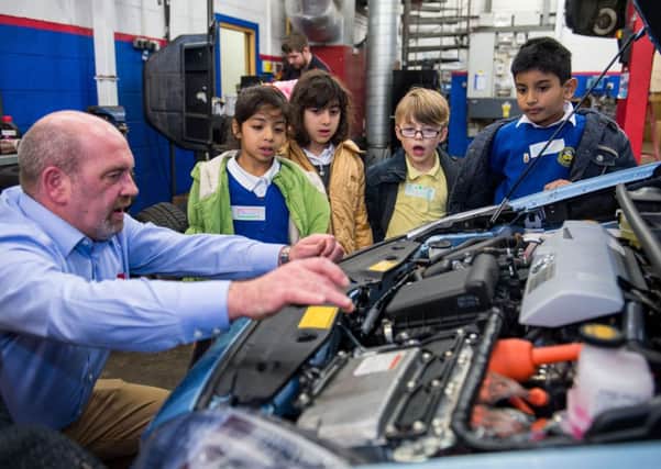 Fajr Sarwar, Sorina Kaimasidi, Matthew MacDonald and Ayaan Abbasi are shown the hybrid engine of a Toyota Prius by Scott Murray at the Western Toyota Garage on Dalkeith Road. Picture: Ian Georgeson