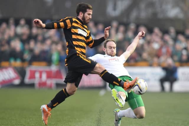Hibernian's David Gray slides in on Liam Buchanan (left). Picture: SNS Group