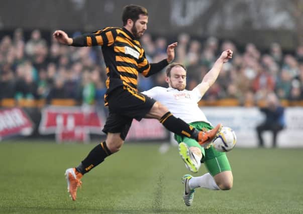 Hibernian's David Gray slides in on Liam Buchanan (left). Picture: SNS Group