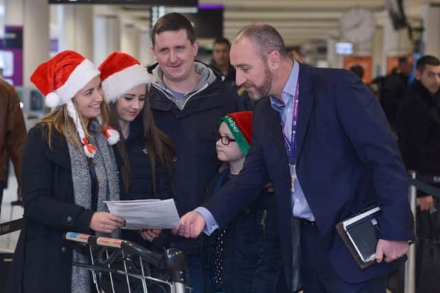The Kennedy family get some help from the airports David Wilson. Picture: Neil Hanna