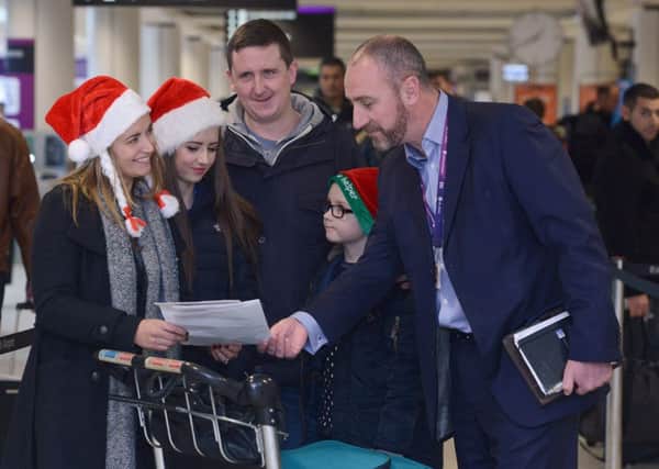 The Kennedy family get some help from the airports David Wilson. Picture: Neil Hanna