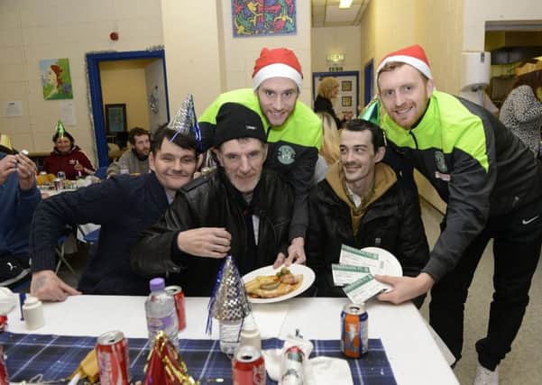 Hibs players Liam Craig and David Gray, service a Christmas meal  and give out tickets to a game and presents to the homeless at Streetwork.