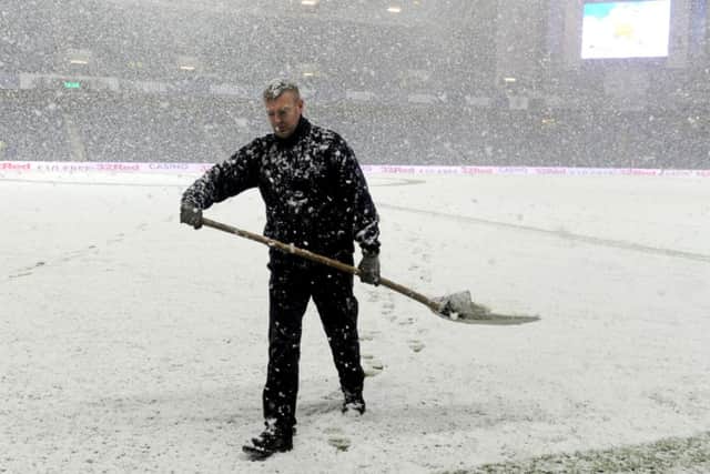 A groundsman tries to clear the pitch before the game. pic: Lisa Ferguson