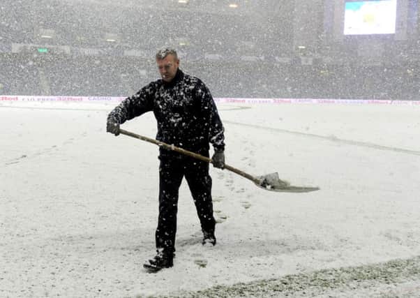 A groundsman tries to clear the pitch before the game. pic: Lisa Ferguson