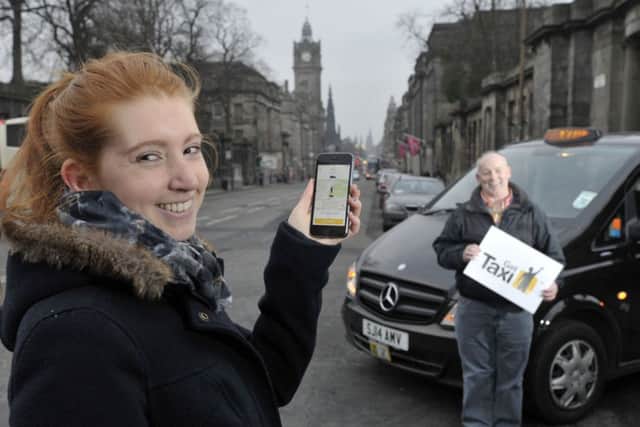 Student Lara Magyar tries out the new taxi app with the help of taxi driver David Sutherland. Picture: Ian Rutherford