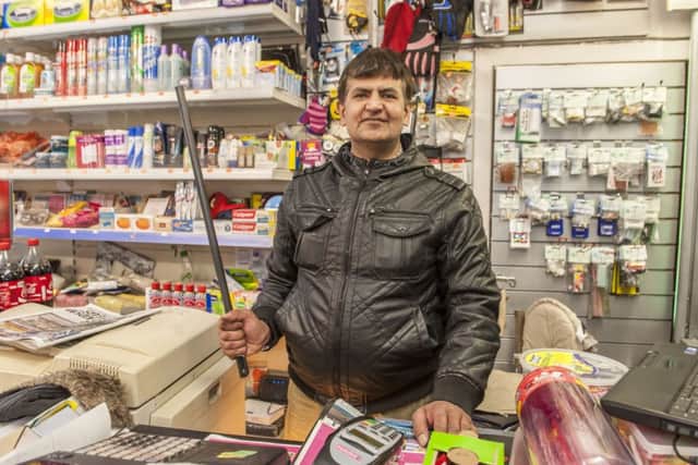 Muhammad Afzal Hanif with the pole he keeps behind the shop counter. Picture: Phil Wilkinson