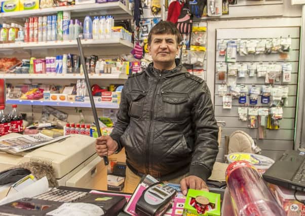 Muhammad Afzal Hanif with the pole he keeps behind the shop counter. Picture: Phil Wilkinson