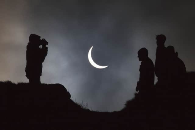 People watch the eclipse on Arthur's Seat. Picture: Toby Williams