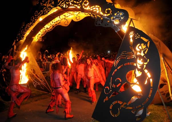 Revellers make their way under the arch of flame. Picture: Jane Barlow