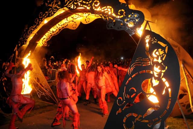 Revellers make their way under the arch of flame. Picture: Jane Barlow