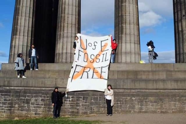 The student protesters unveil a banner on Calton Hill