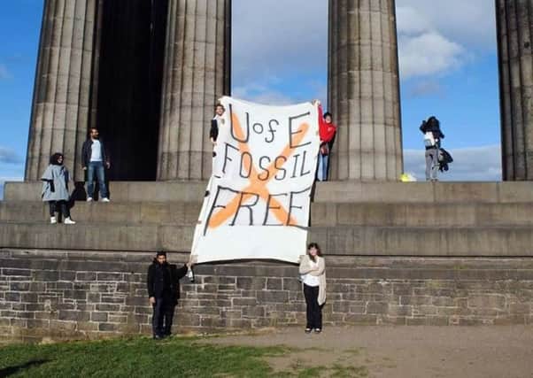 The student protesters unveil a banner on Calton Hill