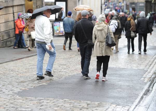 Unsightly tarmac has been placed on the cobbles at the top of the Royal Mile, much to the anger of traders. Picture: Neil Hanna