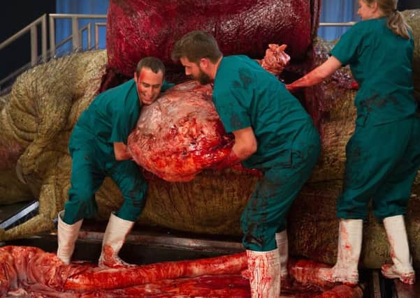 Dr Steve Brusatte, left, and Matthew T Mossbrucker lift the T-Rex stomach out of the body