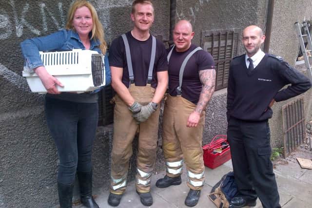 Albert with owner Karyn Tracey, Animal Rescue Officer Darren Malcolm and firemen. Picture: Scottish SPCA