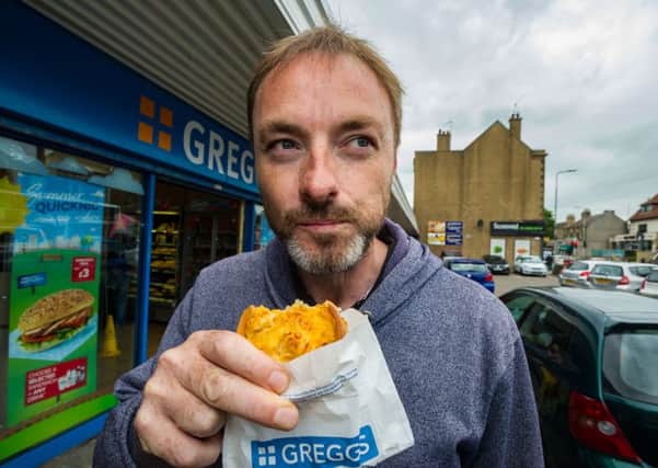 Jason Keddie enjoys a Greggs macarroni pie from the Corstorphine Shop while he still can. Picture: Scott Taylor