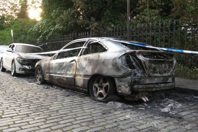 Crime scene tape cordons off the  burnt-out Mercedes and the badly damaged BMW. Picture: John Wallace