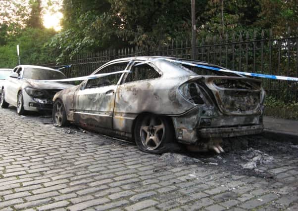 Crime scene tape cordons off the  burnt-out Mercedes and the badly damaged BMW. Picture: John Wallace