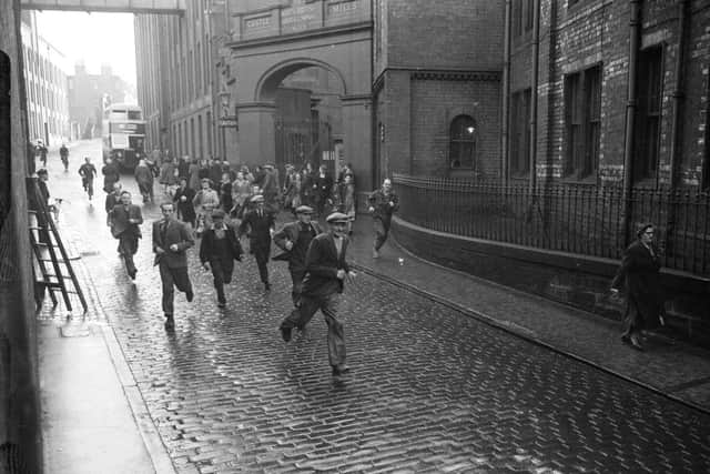 Staff run out of the Castle Mills factory at the end of their shift in November 1951. Picture: TSPL