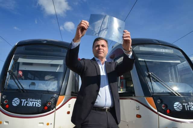 Ian Craig with a sheet of UV-resistant film which is going to fitted over the windows of the Edinburgh trams. Picture: Jon Savage