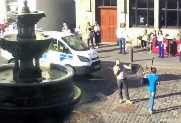 The man is confronted by the young bagpiper as the police arrive. Picture: Contributed