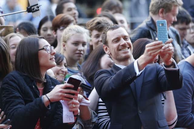 Actor Michael Fassbender, seen taking selfies with fans, plays Macbeth who is portrayed as a battle-weary soldier who is suffering post-traumatic stress disorder. Picture: PA