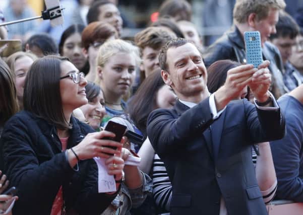 Actor Michael Fassbender, seen taking selfies with fans, plays Macbeth who is portrayed as a battle-weary soldier who is suffering post-traumatic stress disorder. Picture: PA