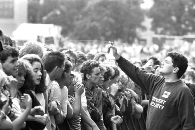 A Concert Security guard sprays the audience with water during a Simple Minds concert at Meadowbank stadium in Edinburgh, August 1989.