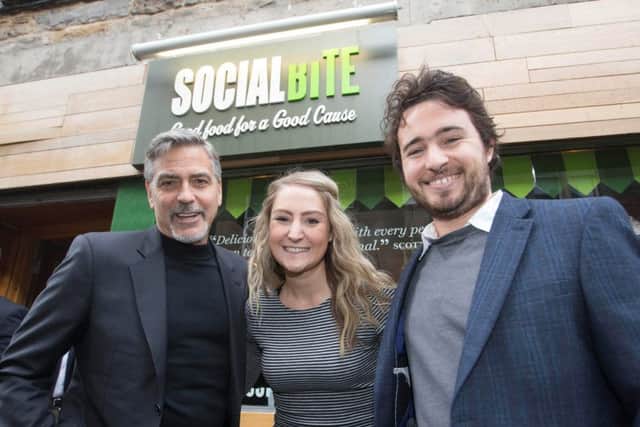 Hollywood A-lister George Clooney(L) with owners Josh Littlejohn(R) and Alice Thompson when he visited the not-for-profit sandwich shop Social Bite in Edinburgh.