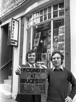 Owners Brian Findlay and Bruce Findlay with the distinctive red carrier bag 'I Found It At Bruce's' outside Bruce's record shop in Rose Street Edinburgh  in November 1972