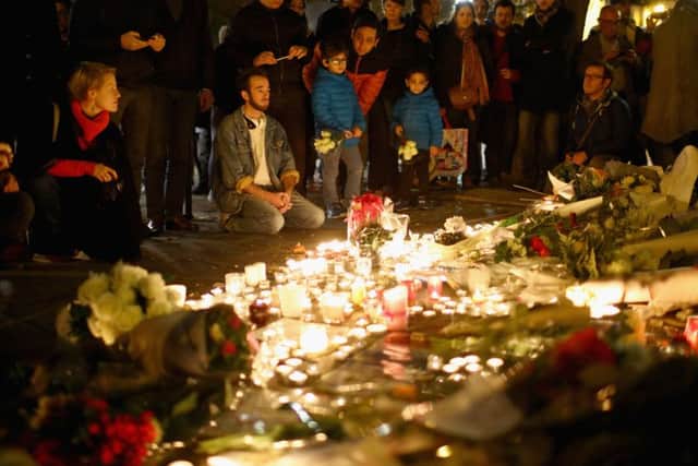 Flowers and candles are left on the pavement near the scene of the Bataclan Theatre terrorist attack. Picture: Getty