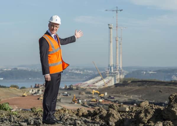 Finance Secretary John Swinney with the Queensferry Crossing under construction. He is to consider compensation over closure. Picture: Phil Wilkinson