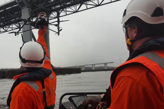 Engineers look on as a drone carries out inspection work on the road bridge. The device is used to gather images of the bridges many components, particularly those hard to otherwise access