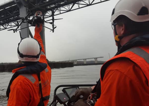 Engineers look on as a drone carries out inspection work on the road bridge. The device is used to gather images of the bridges many components, particularly those hard to otherwise access