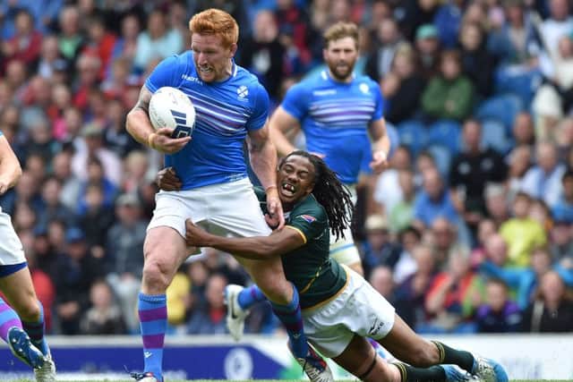 Roddy Grant is tackled by Cecil Afrika during Scotland's match with South Africa at the 2014 Commonwealth Games. Picture: Ian Rutherford
