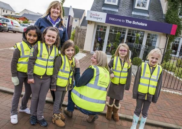 Taylor Wimpeys sales executive June Mcleod with members of 5th Dalkeith Brownies with their new high-viz vests