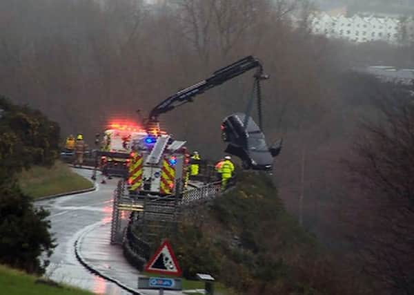 The car left hanging over the verge is hauled to safety. Picture: STV