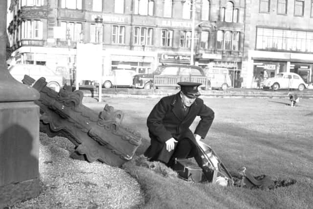A policeman inspects the damage to Princes Street Gardens after a floodlight and stonework are dislodged from the Scott Monument by the January gales in 1968. Picture: TSPL